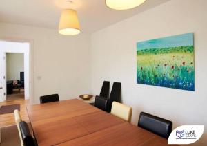 West CornforthLuke Stays - The Green的一间设有桌子和墙上绘画的用餐室