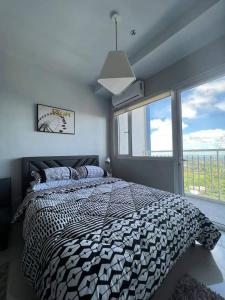 大雅台SMDC Wind residences的一间卧室设有一张床和一个大窗户