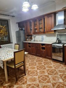 第比利斯Benevo Hostel的厨房配有木制橱柜、桌子和炉灶。