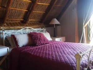 普利登堡湾SHABBY FUFU LIFESTYLE FARM的卧室内的一张带紫色棉被的床