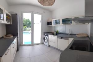 勒迪亚芒Villa en bord de mer, vue mer au Diamant的白色的厨房配有水槽和洗衣机