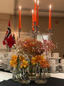 Kirkenær斯卡斯利恩酒店及宾馆的一张桌子,桌子上放着花花花花花,桌上放着蜡烛