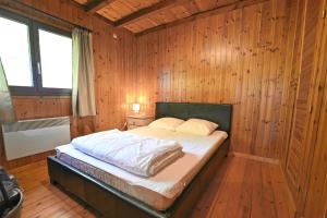 索姆勒兹Hortensias的卧室配有木墙内的一张床