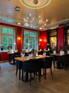 巴特本特海姆Hotel Bentheimer Hof的一间带桌椅和吊灯的餐厅