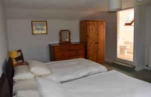 皮特洛赫里Craignuisq Farmhouse的一间卧室设有两张床、一个梳妆台和窗户。
