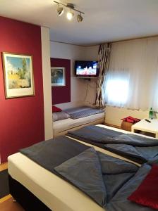 温德哈根Hotel/Restaurant Adria的一间卧室设有两张床,墙上配有电视。