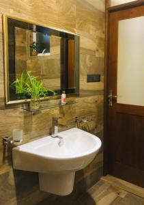 康提Tranquil Quarter的浴室设有白色水槽和镜子