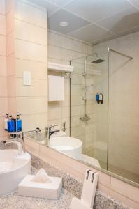迪拜Best Western Plus Dubai Academic City的一间带水槽和玻璃淋浴的浴室
