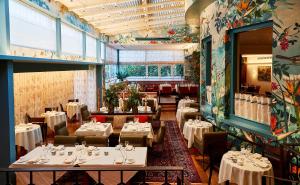 圣奥尔本斯思博温酒店的一间设有白色桌椅的餐厅和一间设有桌子的房间
