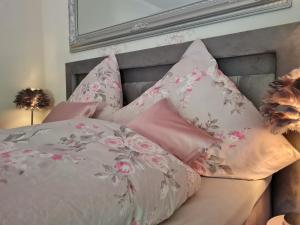 ÜdersdorfGasthaus Paula的床上配有粉红色和粉红色枕头的床