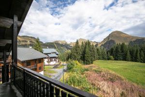 塔南日Côté Montagne的享有田野和山脉景色的房屋阳台