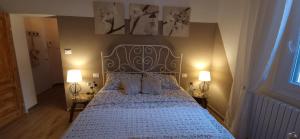博洛尼亚Minimal Chic House的一间卧室配有一张带蓝色床罩和两盏灯的床。