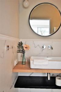 格但斯克Patio Riverfront Aparthotel的一间带水槽和镜子的浴室