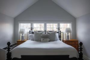 Wauwinet沃威内特纳塔基特酒店的卧室配有一张白色大床和两个窗户