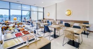 波尔图room Select Porto的餐厅设有桌椅,供应自助餐。