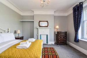 卡迪夫Traditional 3-Bed Property in Pontcanna with Parking的一间卧室配有黄色的床和镜子