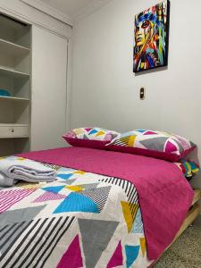 麦德林Hostel Kumho alojamiento的一间卧室,床上有五颜六色的被子