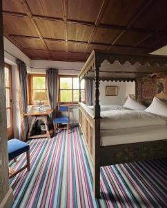 安达赫治Hotel Schrenkhof的一间卧室配有一张床、一张桌子和一张桌子