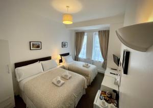 伦敦盖特威酒店的酒店客房设有两张床和电视。