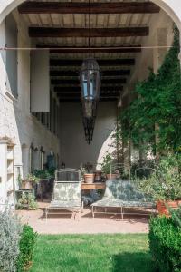 雷焦艾米利亚Casale Hortensia的天井设有2张长椅和吊灯。