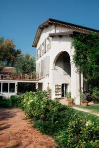 雷焦艾米利亚Casale Hortensia的白色房子的一侧有拱门