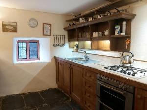 赖厄德Longhouse - Y Beudy的厨房配有炉灶、水槽和窗户。