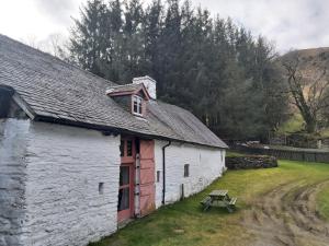 赖厄德Longhouse - Y Beudy的前面有一张野餐桌的白色建筑