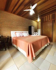 圣本图-杜萨普卡伊Chalés Sapucaí Pousada的一间卧室设有一张床和砖墙