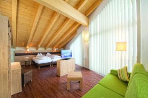 萨尔巴赫Hotel ALPINA的客厅配有绿色沙发和床。