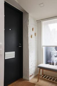 赫尔辛基2ndhomes Unique 35m2 Studio Penthouse with Sauna & Balcony的一间设有黑色门和窗户的房间