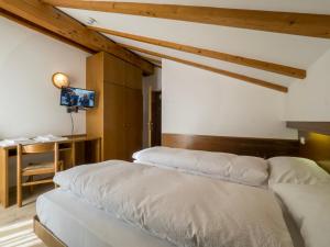 平佐洛Hotel Ferrari的一间卧室设有两张床,墙上配有电视。