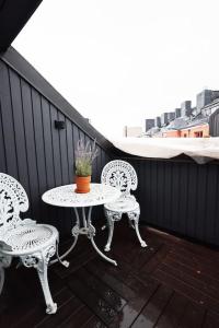 赫尔辛基2ndhomes Unique 35m2 Studio Penthouse with Sauna & Balcony的阳台的天井配有2把椅子和1张桌子