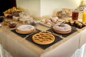 平佐洛Hotel Ferrari的一张桌子,上面放有不同种类的蛋糕和糕点