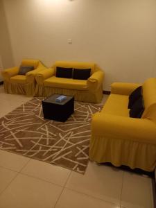 巴哈بيوتات الزير的客厅配有两张黄色沙发和地毯