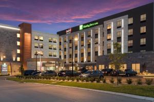蒙特朱丽叶Holiday Inn & Suites - Mt Juliet Nashville Area, an IHG Hotel的停车场内停放汽车的酒店大楼