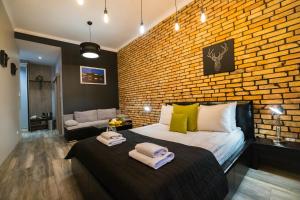 克拉科夫Leo Apartments Main Square的一间卧室设有砖墙和一张床