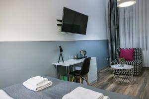 克拉科夫Leo Apartments Main Square的酒店客房设有一张床、一张书桌和一台电视机。