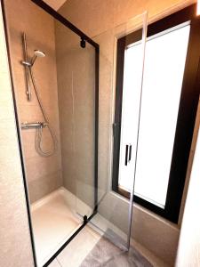 Bossut-Gottechain萨库拉公寓的浴室内带玻璃门的淋浴间