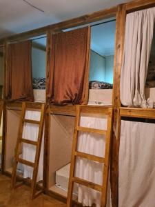 第比利斯Benevo Hostel的带2个梯子的客房内的2张双层床