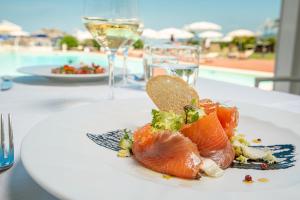 费拉约港Hotel Airone isola d'Elba的一张带寿司的桌子上的白板,带游泳池