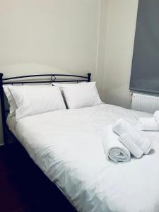 蒂米萨那Ortansia的一张带白色床单和毛巾的床