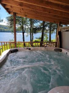 Rivière-RougeAlison On Lake & Romantic Getaway With Private Hot Tub的小屋内的热水浴池,享有水景