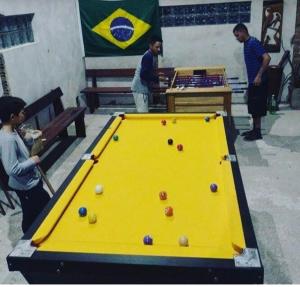佩洛塔斯Pousada das Palmeiras的一群人站在台球桌旁