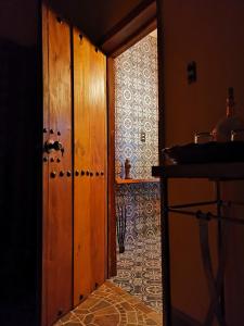 EkpedzHotel Tihosuco Colonial的走廊上设有一扇门,通往一间铺有瓷砖地板的厨房