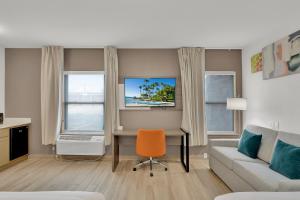 南帕诸岛Comfort Inn的客厅配有书桌和沙发。