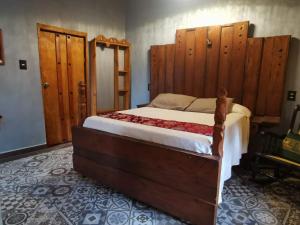 EkpedzHotel Tihosuco Colonial的一间卧室配有一张带木制床头板的大床