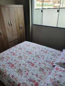 圣罗克迪米纳斯Apart-Hotel Canastra的一间卧室配有一张带花卉床罩的床和窗户。