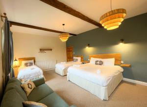 沙普New Ing Lodge的一间带两张床和一张沙发的客厅