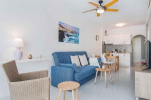 莫罗德哈布雷RELAX JANDIA的一间带蓝色沙发的客厅和一间厨房
