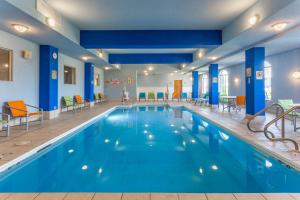 Loves Park罗克福德洛芙斯公园快捷假日酒店的一座拥有蓝色墙壁和椅子的酒店游泳池